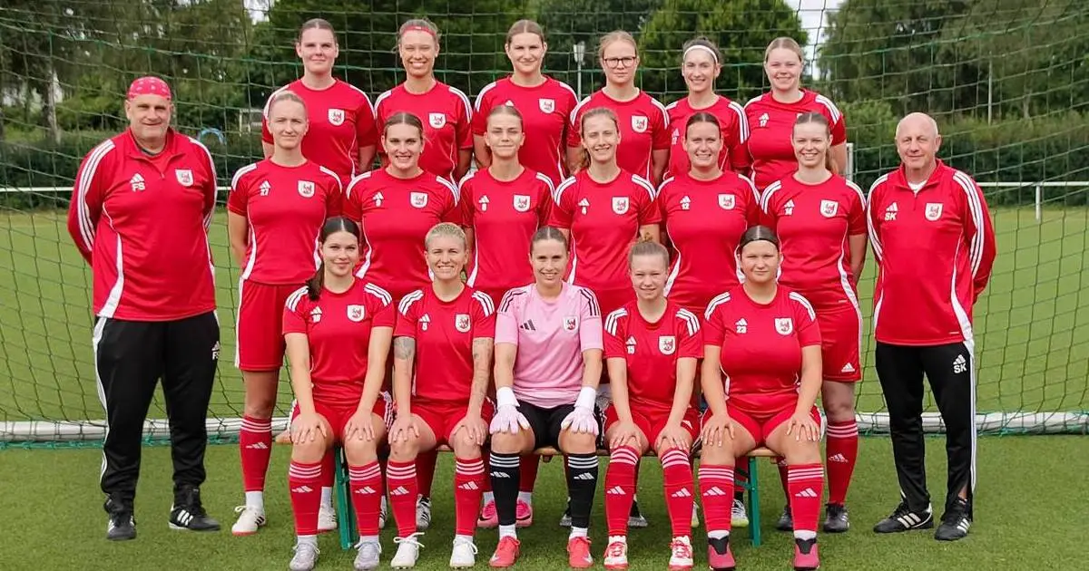 Mannschaftsfoto der 1. Frauen in roten Trikots, roten Hosen und roten Stutzen.