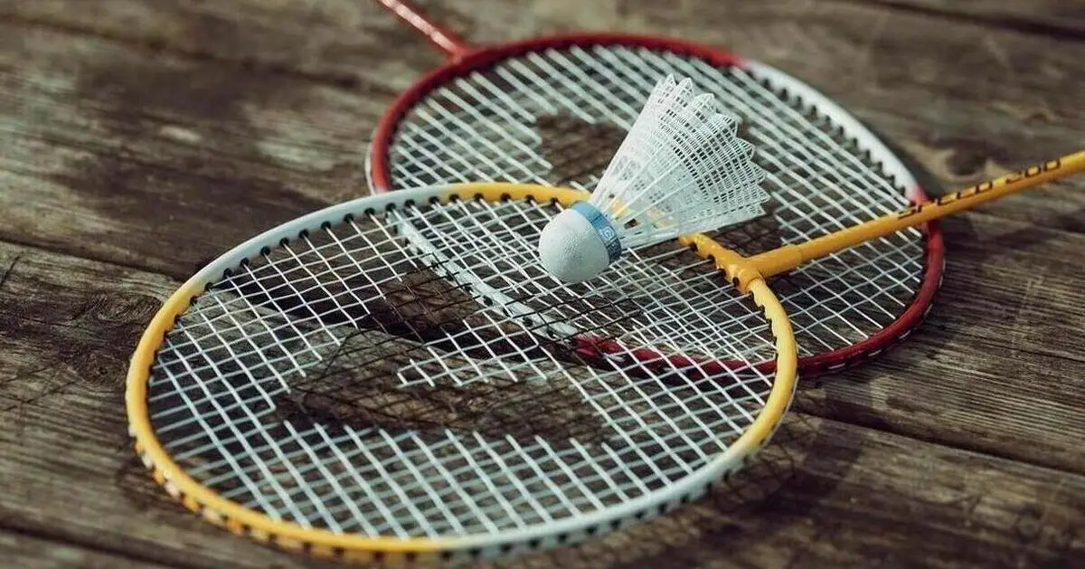 Zwei Badmintonschläger liegen auf einer Holzoberfläche